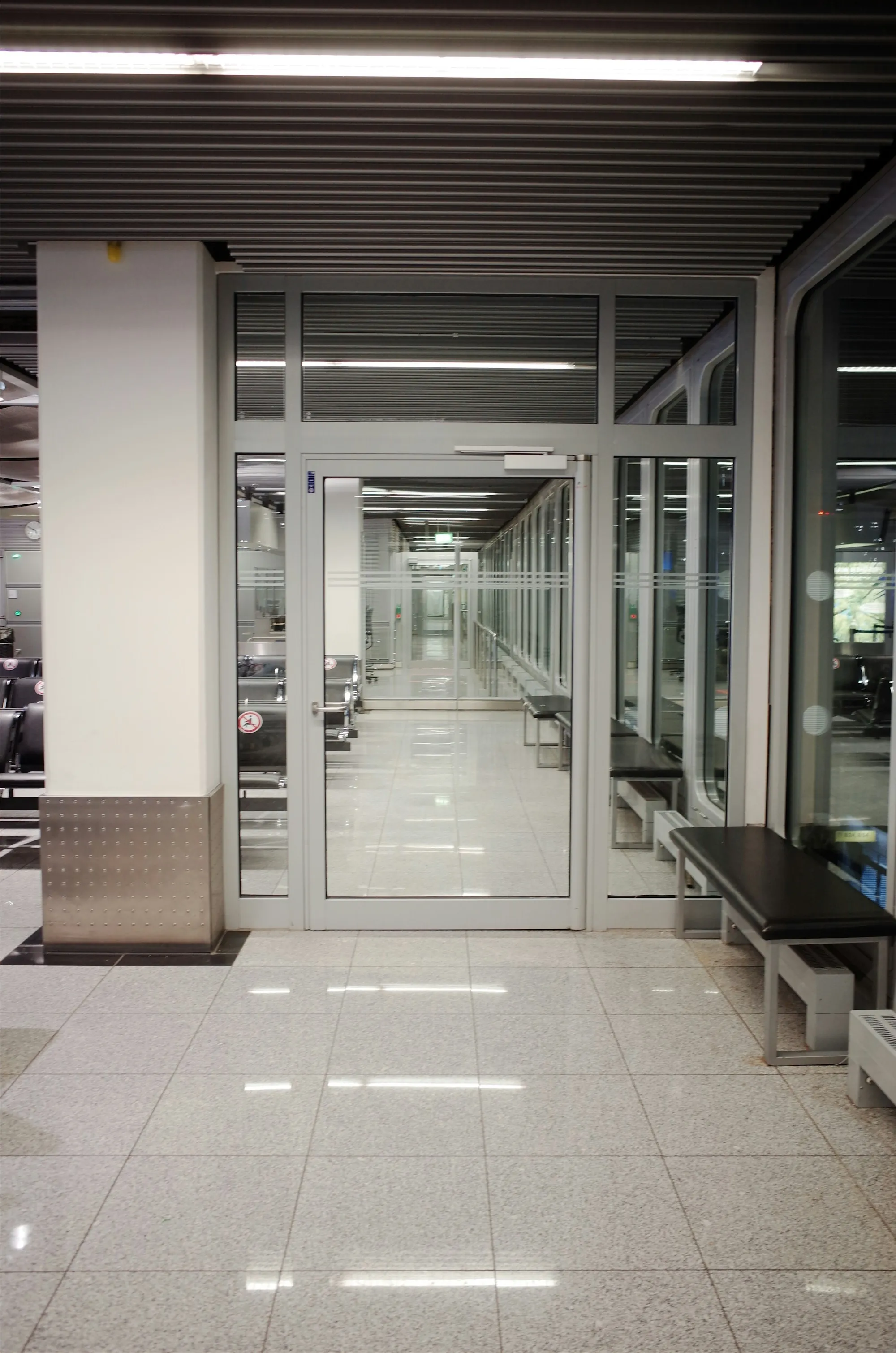 Clean office corridor with glass doors and a tile floor
